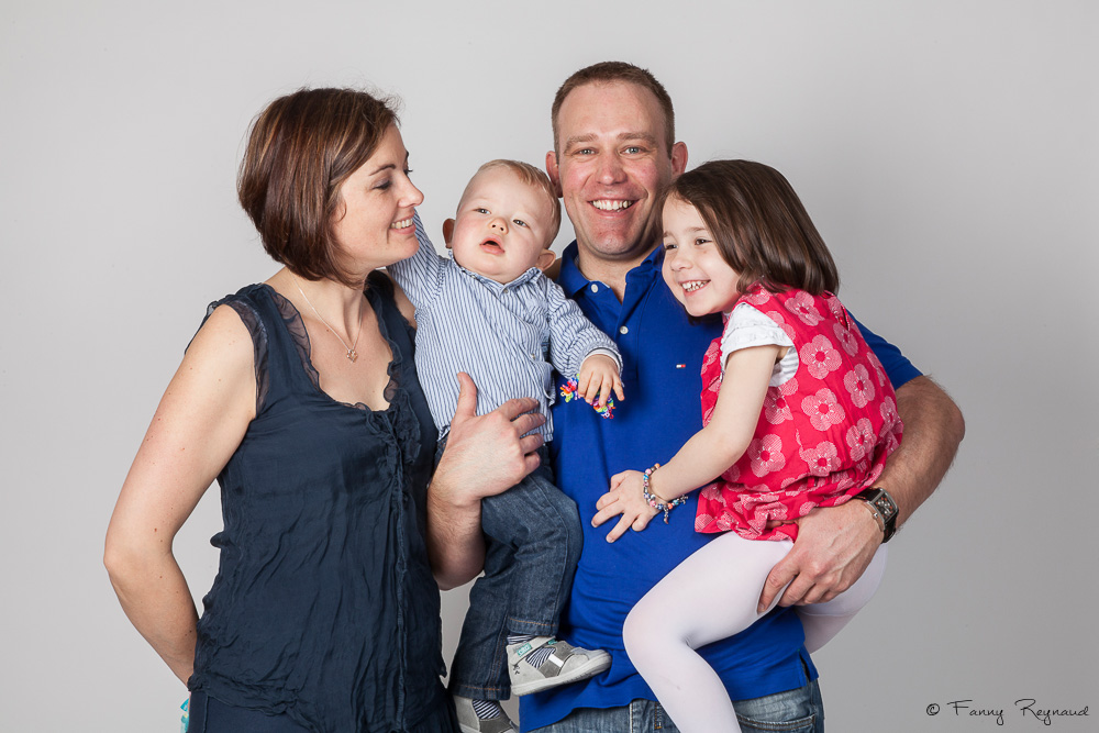 Photographie d'un couple et leurs deux jeunes enfants en studio, pendant une séance en studio en famille.