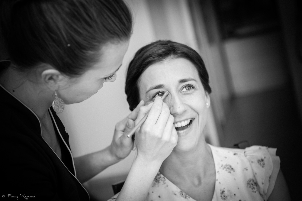 La mariée sourit pendant la séance de mariage avant son mariage. Photographie noir et blanc prise en auvergne par un photographe professionnel.