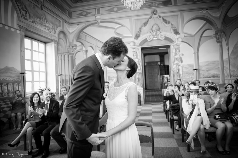 Photographie du baiser des mariés à la mairie de clermont-ferrand, dans le puy-de-dome. Photo noir et blanc professionnelle style vintage par une photographe professionnelle.
