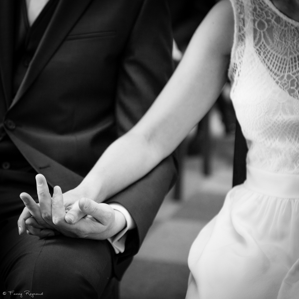 Photographie de détails des mains liées des mariés pendant un mariage civil à clermont-ferrand en auvergne. Photo noir et blanc professionnelle.