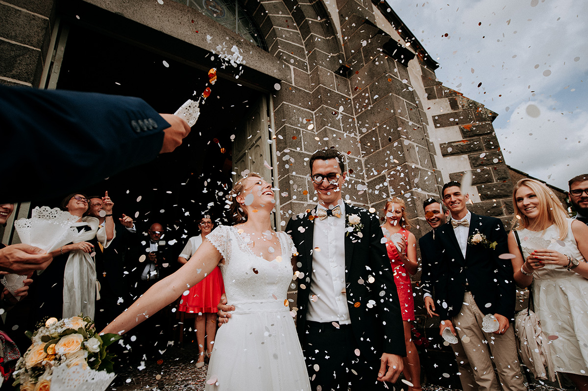 lancé de confettis à la sortie de l'église mariage en auvergne, photographe professionnel