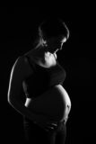 photographie d'une femme enceinte en noir et blanc en studio, à clermont-ferrand, shooting grossesse par un photographe professionnel