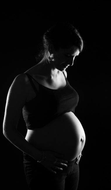 photographie d'une femme enceinte en noir et blanc en studio, à clermont-ferrand, shooting grossesse par un photographe professionnel