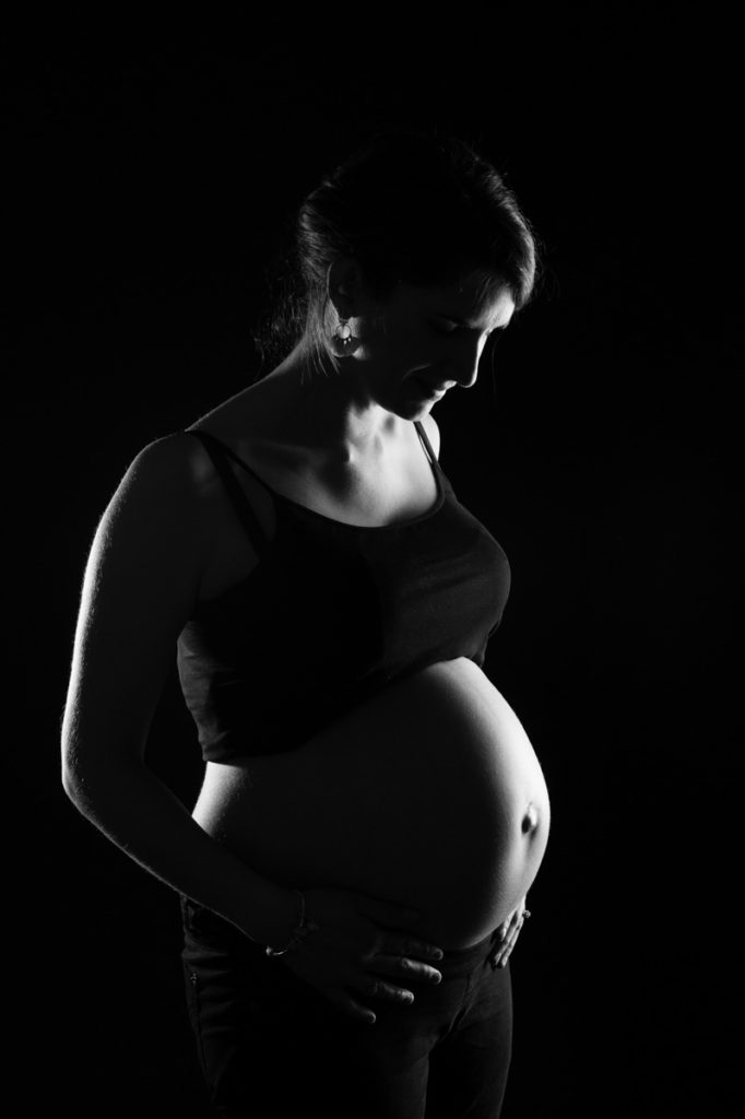 photographie d'une femme enceinte en noir et blanc en studio, à clermont-ferrand, shooting grossesse par un photographe professionnel