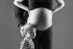 Photo en noir et blanc d'une femme enceinte avec sa petite fille. Fanny Reynaud photographe grossesse à clermont-ferrand